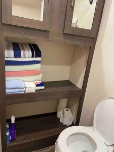 a bathroom with a toilet and some towels at Mini home with bathroom, kitchen in Houston