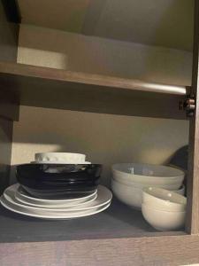 a shelf with plates and bowls in a cabinet at Mini home with bathroom, kitchen in Houston