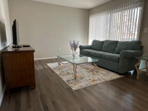 a living room with a couch and a glass table at Cozy Retreat 1.8 Mi to Stadium in Gainesville