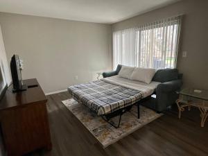 a living room with a bed and a window at Cozy Retreat 1.8 Mi to Stadium in Gainesville