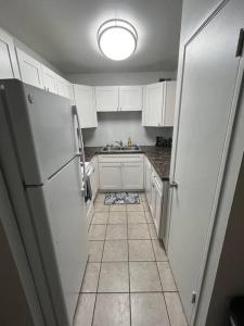 a kitchen with white cabinets and a white refrigerator at Cozy Retreat 1.8 Mi to Stadium in Gainesville