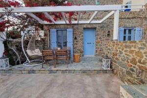 un patio con mesa y sillas frente a un edificio en Aqua Blu Syros 1,3 en Posidhonía