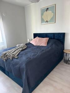 ein Schlafzimmer mit einem blauen Bett in einem Zimmer in der Unterkunft Cozy apartment near to the beach in Pärnu
