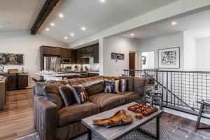 a living room with a brown couch and a table at Creekhouse 1583 in Mammoth Lakes