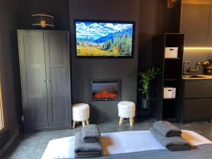 salon z telewizorem i kominkiem w obiekcie Modern Black Studio Penthouse En Valle De Incles - Parking Gratis w mieście Canillo