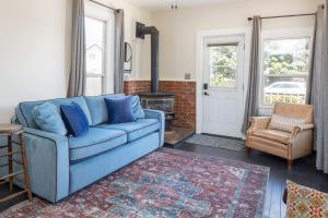 un sofá azul en una sala de estar con chimenea en Wynkoop at Carlton: Taste of Europe, Walk to Wineries, Dog Friendly, en Carlton