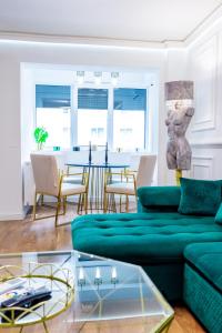 a living room with a green couch and a table at Lady Suite in Cluj-Napoca