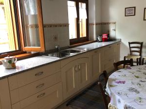 a kitchen with a sink and a table with a table gmaxwell gmaxwell gmaxwell at Casa della Meridiana in Clastra