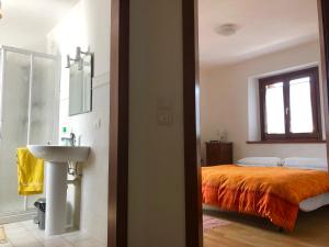 a bathroom with a bed and a sink and a mirror at Casa della Meridiana in Clastra