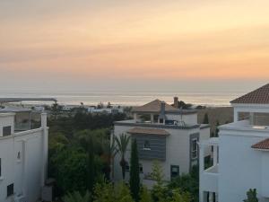 a view of the ocean from the roofs of buildings at Les magnifiques jardins d’Assilah in Asilah