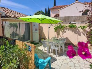 a patio with a table and chairs and an umbrella at Les Loulous in Ceyreste