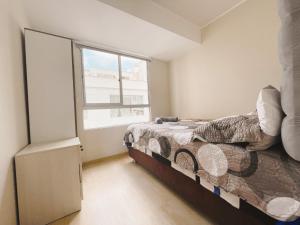 un dormitorio con una cama y una ventana en Hermosa habitación privada en edificio de estreno frente al metro, en Lima 21 fotos más