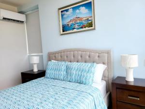 a bedroom with a bed and a picture on the wall at Fantastic Beach condo with pool and mountain views in Nueva Gorgona