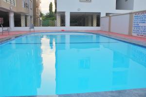 a swimming pool with blue water in a building at Pavillion Suites, pazuri Homes in Mombasa