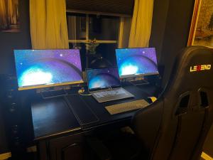a desk with three monitors and a laptop on it at Day to Day Motel in Borlänge
