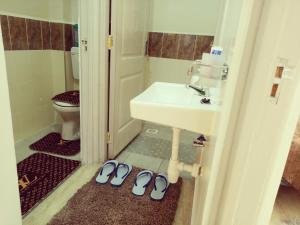 uma casa de banho com um lavatório e dois pares de sapatos em Dream Villa em Ongata Rongai 