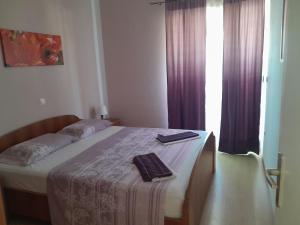 1 cama en un dormitorio con cortinas moradas en Apartments Dobrila, en Ivan Dolac