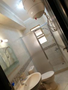 a bathroom with a toilet and a shower and a sink at Telal Ground Floor 2 bedroms in Ain Sokhna