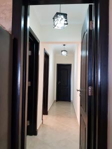un pasillo con una puerta negra y un pasillo con un pasillo en Telal Ground Floor 2 bedroms en Ain Sokhna