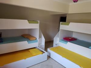 een kamer met 2 stapelbedden met verschillende gekleurde lakens bij Telal Ground Floor 2 bedroms in Ain Sokhna