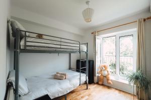 1 dormitorio con 2 literas y un osito de peluche en GoldenGlow Apartment 15 MIN Airport, en Dublín