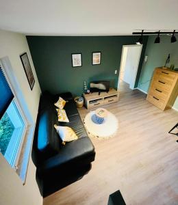 ein Wohnzimmer mit einem schwarzen Ledersofa in der Unterkunft Maisonette für 6P mit toller Aussicht in Hohleborn