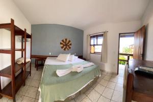 a bedroom with a bed with towels on it at Pousada Flor de Lotus in Itacaré