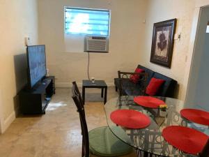 a living room with a table and chairs and a television at Cute Private Room, near the Airport - Free parking - 02 in Miami