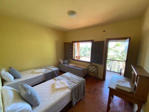 um quarto com duas camas e uma janela em Casa dos Coqueiros - Cama, Café e Eventos em Itabirito
