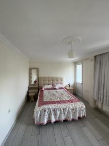 ein weißes Schlafzimmer mit einem großen Bett und einem Fenster in der Unterkunft Havaalanına yakın, karşısı orman ferah bir daire. 
