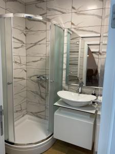 a bathroom with a glass shower and a sink at Apartman Prodan in Sombor