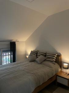a bedroom with a large bed with two pillows at Apartman Prodan in Sombor