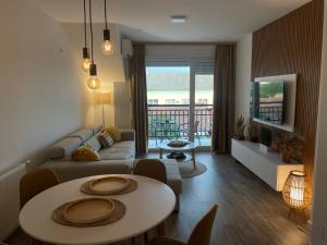 a living room with a couch and a table with chairs at Apartman Prodan in Sombor
