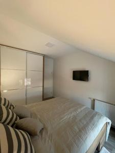a bedroom with a bed and a tv on the wall at Apartman Prodan in Sombor
