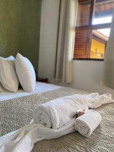 un paio di asciugamani posti sopra un letto di Pousada Flor de Lotus a Itacaré