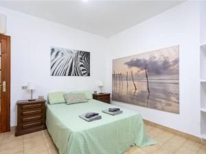 a bedroom with a bed and a painting on the wall at Live Tabaiba Decre con piscina in Tabaiba