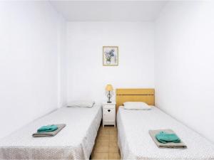 TabaibaにあるLive Tabaiba Decre con piscinaの白い壁の客室で、ツインベッド2台が備わります。