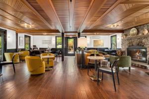 a lobby with tables and chairs and a fireplace at Hotel Mountain Brook in Tannersville