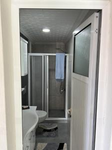 ein Bad mit einer Dusche, einem Waschbecken und einem WC in der Unterkunft Havaalanına yakın, karşısı orman ferah bir daire. 