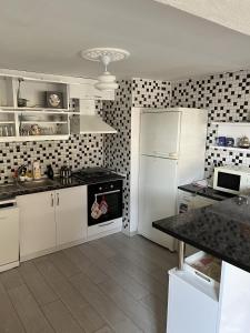 a kitchen with white cabinets and a white refrigerator at Havaalanına yakın, karşısı orman ferah bir daire. 