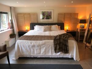 een slaapkamer met een groot bed en 2 lampen bij B&B Nouveauté in Vaals