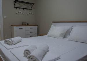 Un dormitorio con una cama blanca con toallas. en DIAMOND OF SKOPJE JB, en Skopje