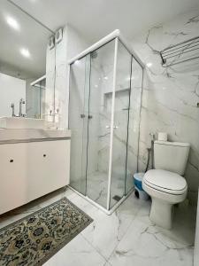 a white bathroom with a toilet and a shower at Apart Ponta Negra Beach Natal -Lovely Flat in Natal