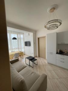 ein Wohnzimmer mit Couch und Tisch und eine Küche in der Unterkunft Appartamento Vista Mare a Valona 5 persone in Vlorë + 15 Fotos