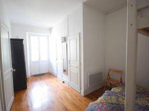 ein leeres Schlafzimmer mit einem Bett und einem Stuhl in der Unterkunft Appartement charmant avec balcon, wifi et animaux admis à Évian-les-Bains - FR-1-498-14 in Évian-les-Bains