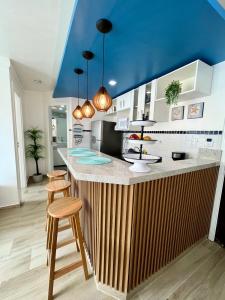 a kitchen with a wooden counter with a blue ceiling at Apart Ponta Negra Beach Natal -Lovely Flat in Natal