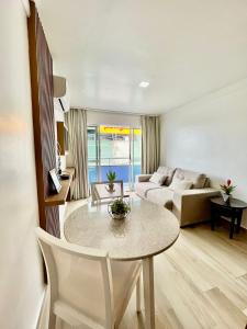 uma sala de estar com uma mesa e um sofá em Apart Ponta Negra Beach Natal -Lovely Flat em Natal