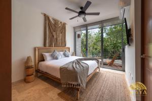 een slaapkamer met een bed, een ventilator en een raam bij Exclusive condominium with pool in Tulum