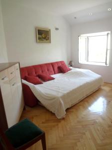 ein Schlafzimmer mit einem roten Sofa in einem Zimmer in der Unterkunft Villa Dijana in Prvić Šepurine