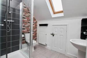 a bathroom with a toilet and a glass shower at Lawnswood Place in Manchester